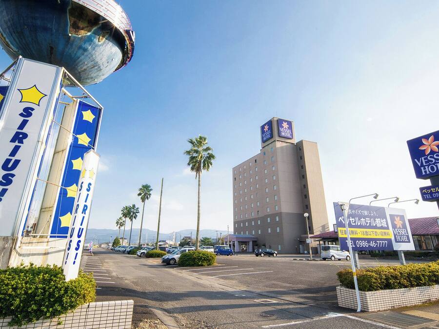 La entrada de un hotel con un cartel grande que dice "SIRIUS!" y varios carteles que indican "VESSEL HOTEL".