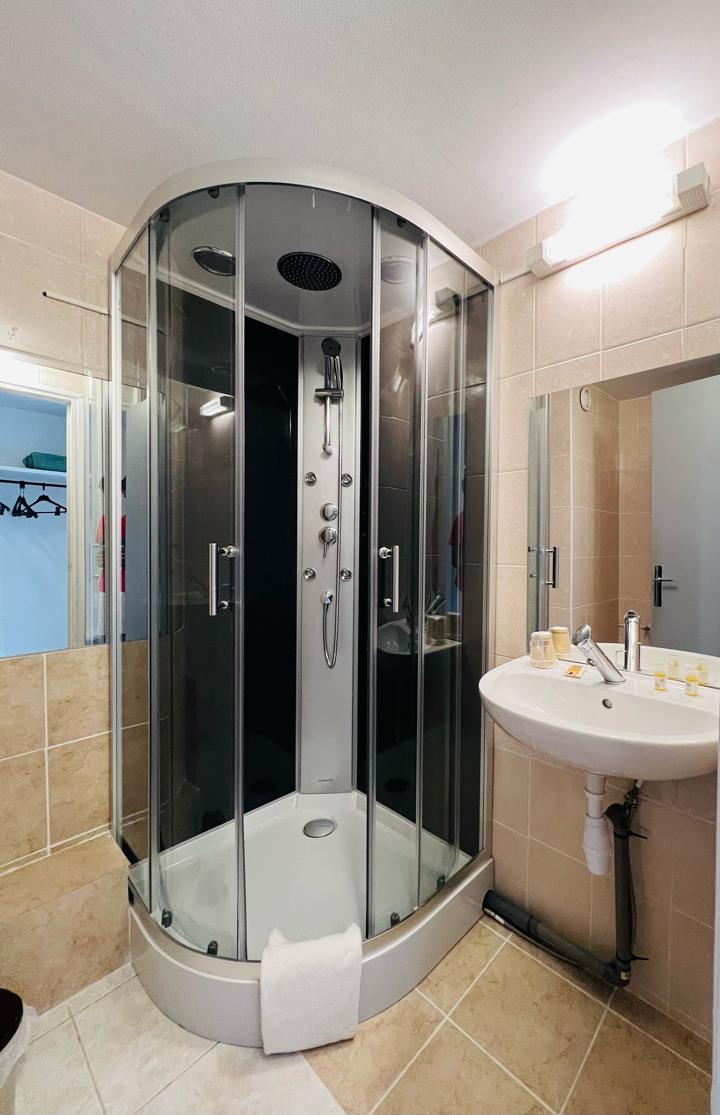 A modern bathroom with a glass-enclosed shower, a sink, and a mirror.