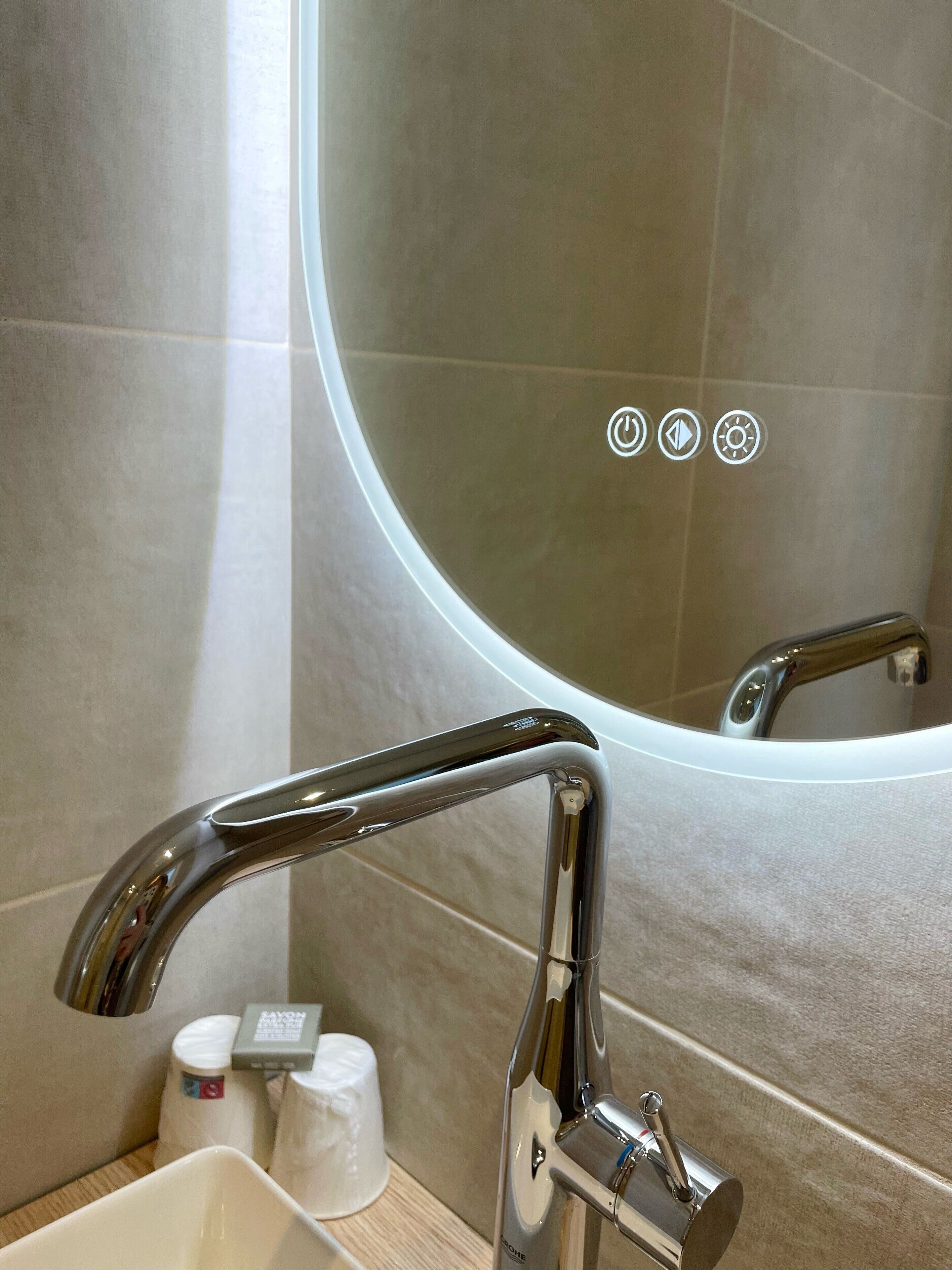 A bathroom with a modern sink, a mirror, and a toilet.