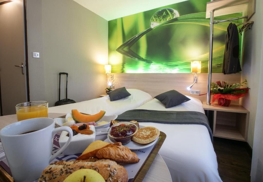 Une chambre d’hôtel avec un lit, un plateau de petit-déjeuner et une fresque murale.