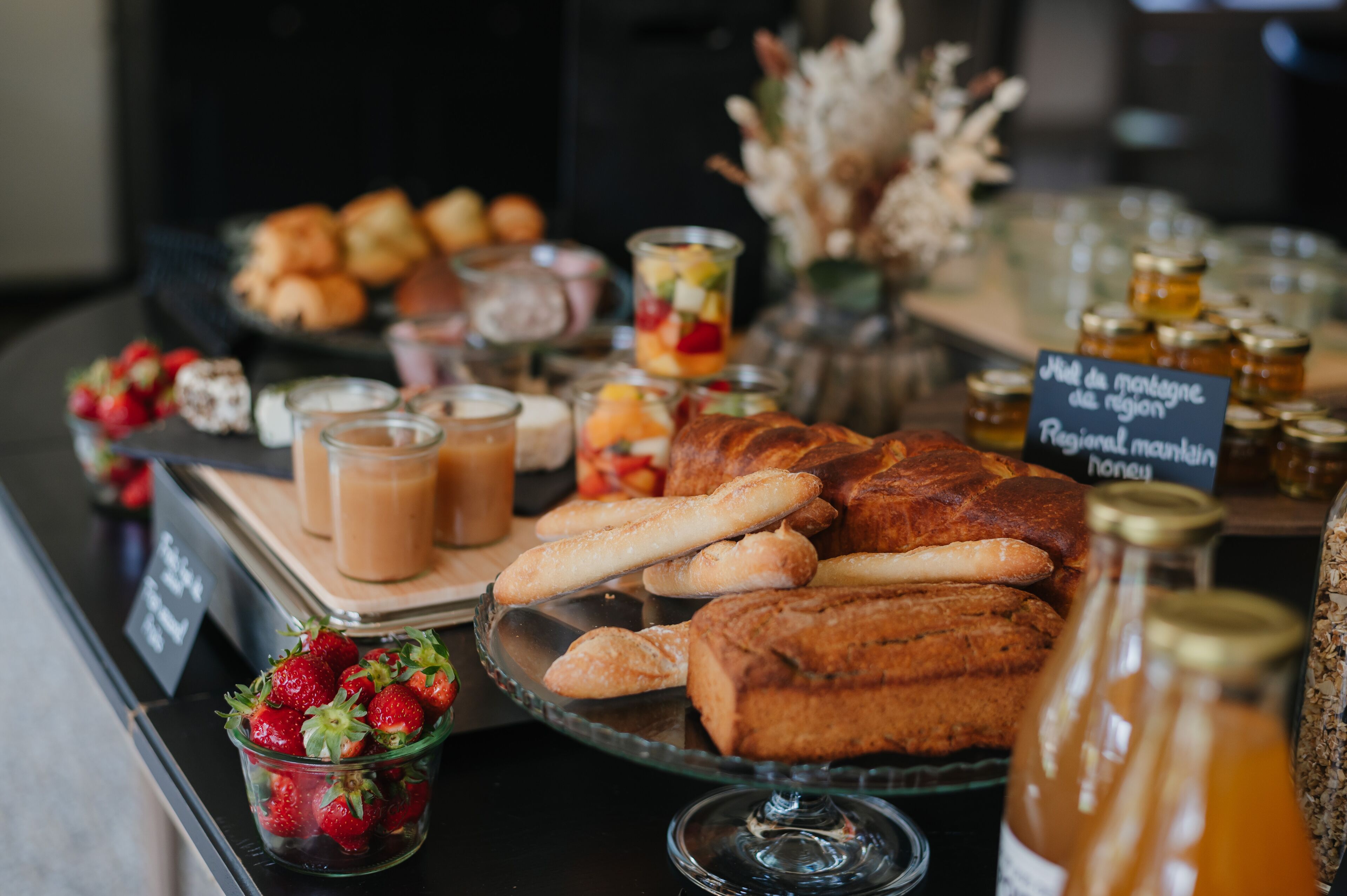 A buffet with various food items including pastries, fruits, and beverages.