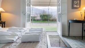 A hotel room with a bed, towels, a table, and a view of mountains through an open door. - Hotel La Robeyere, BW Signature Collection (Embrun)