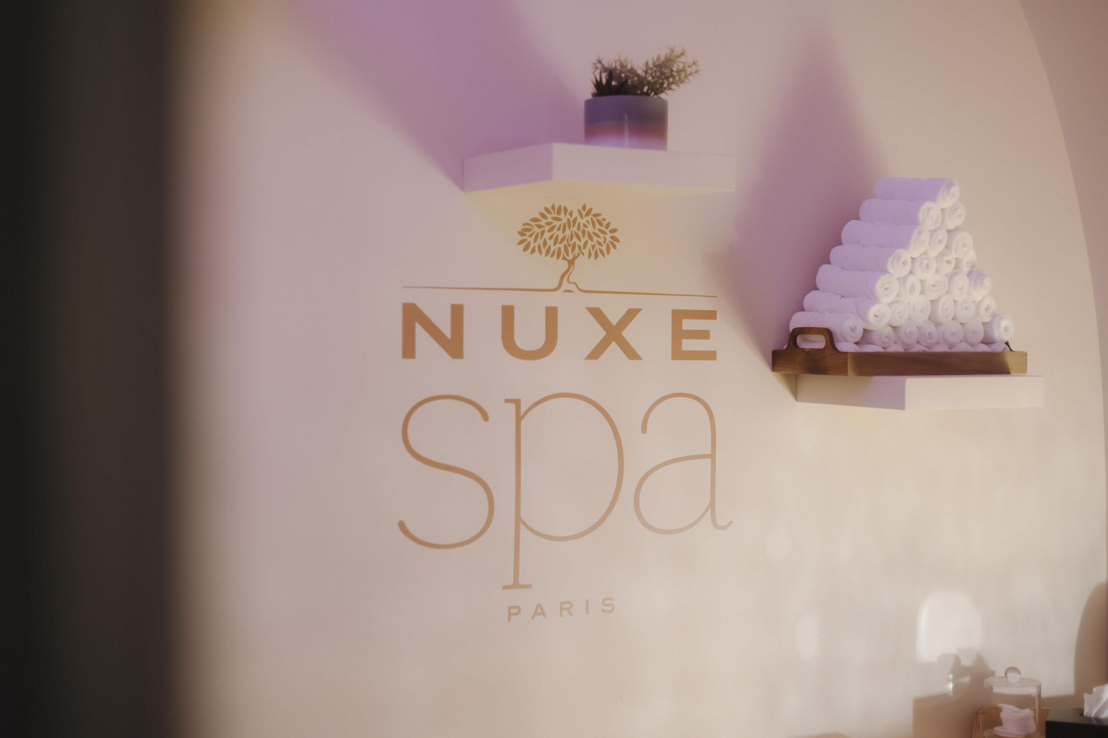 A spa sign with the name 'NUXE SPA PARIS' and a stylized tree logo.