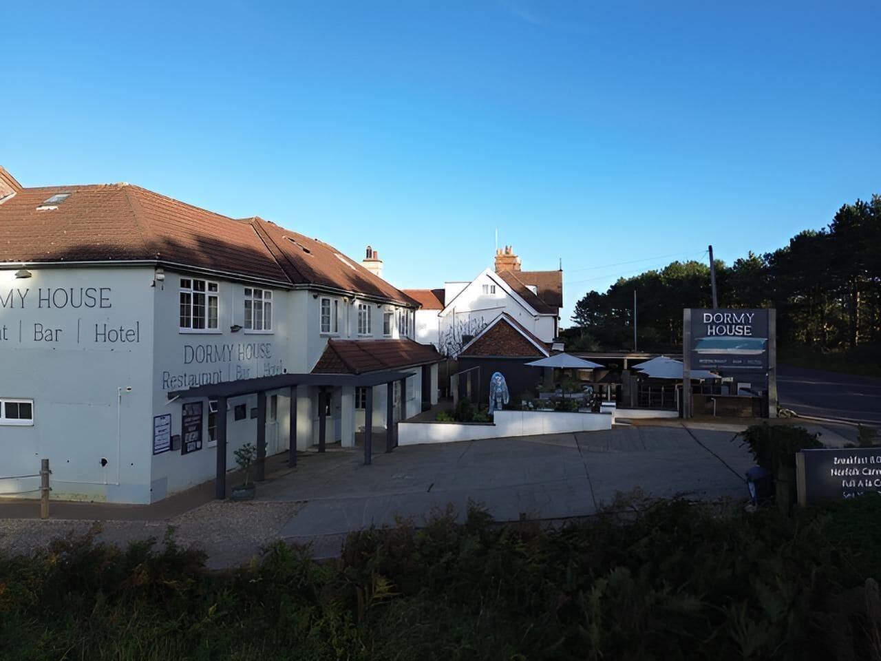 A building with signs for 'DORMY HOUSE Restaurant Bar Hotel' and 'DORMY HOUSE.'
