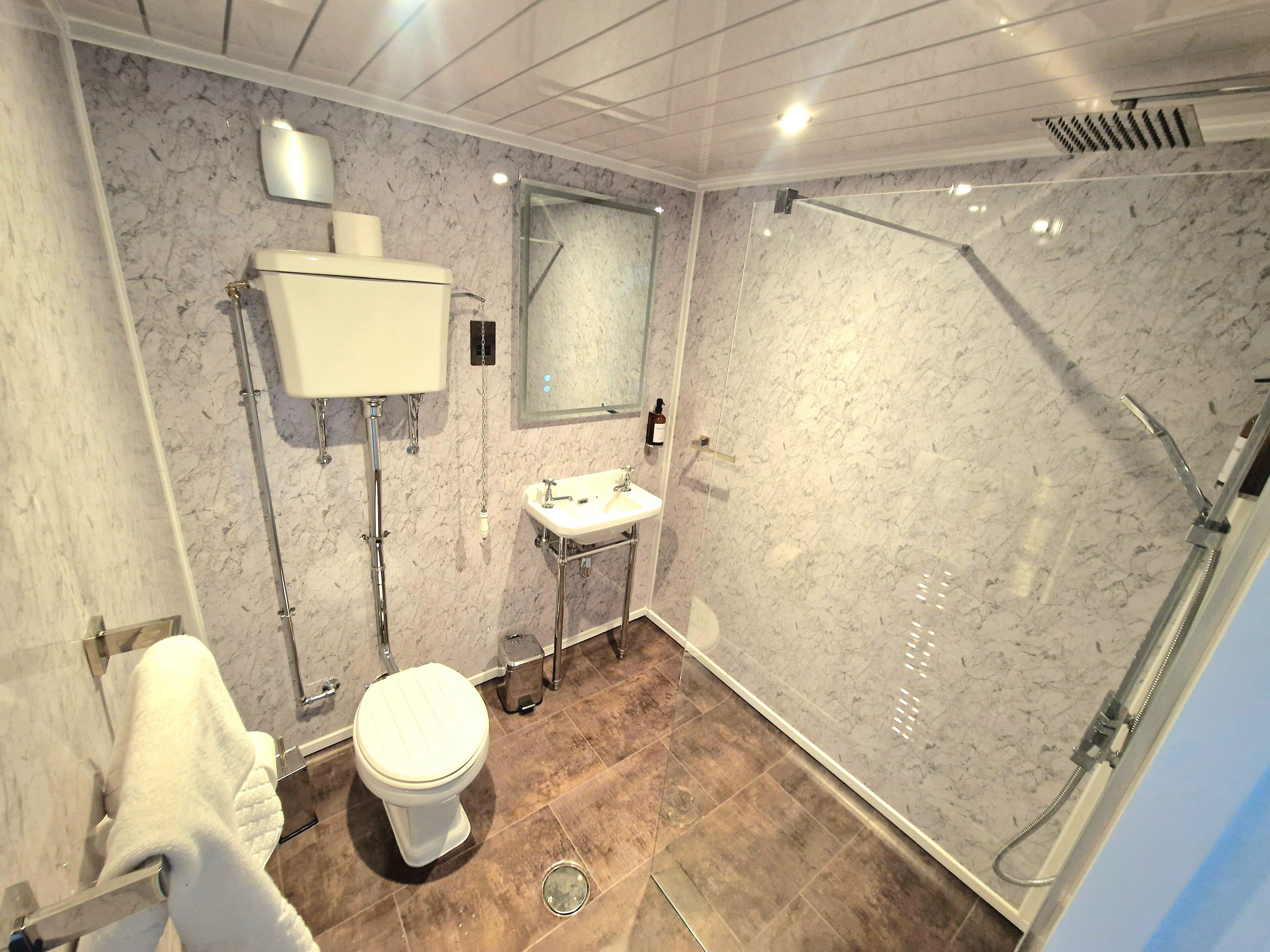 A bathroom with a toilet, sink, and shower.