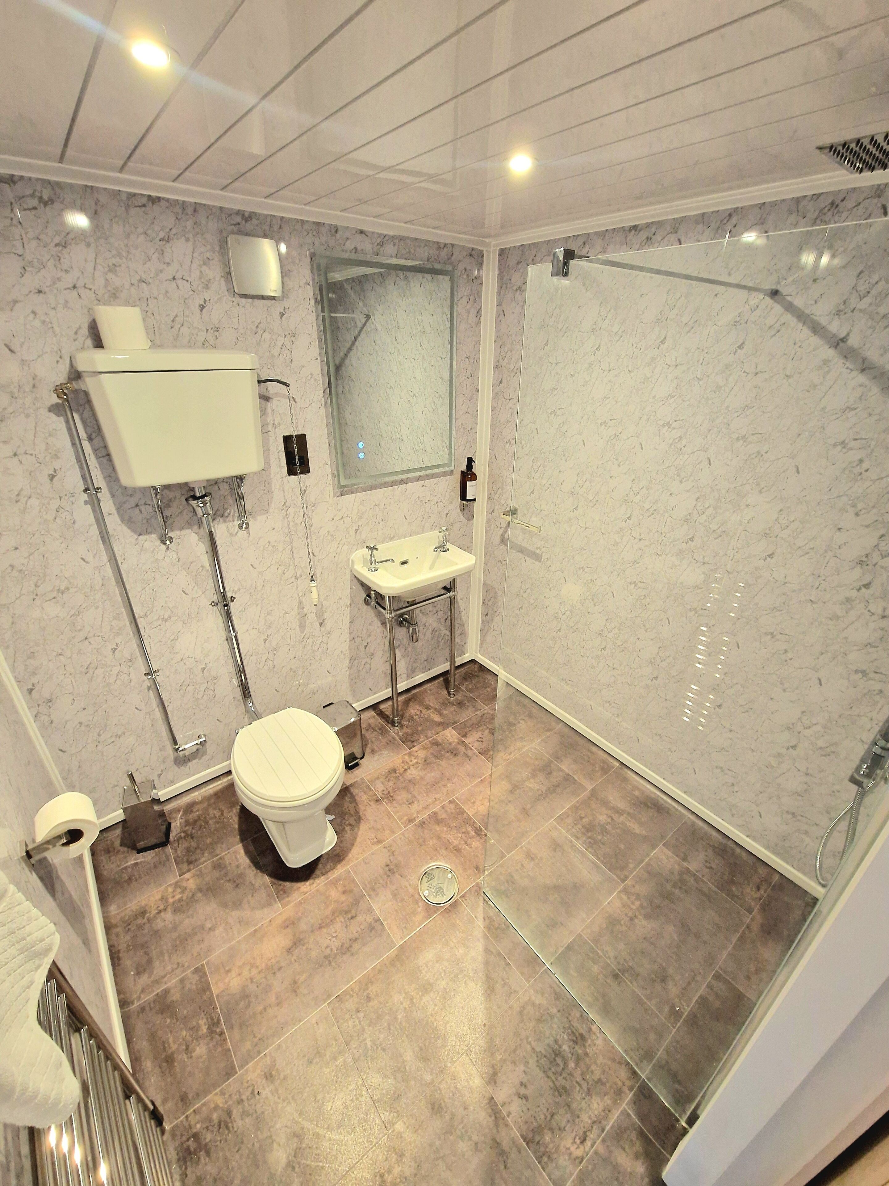 Ein modernes Badezimmer mit Toilette, Waschbecken und Dusche.