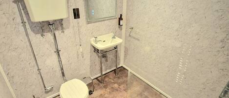 Ein modernes Badezimmer mit Toilette, Waschbecken und Dusche.