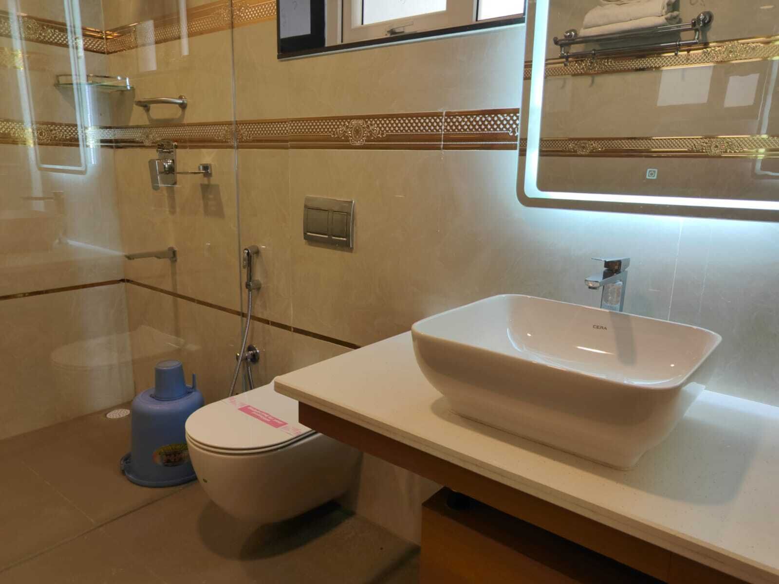 A bathroom with a white sink, a toilet, and a glass shower enclosure.