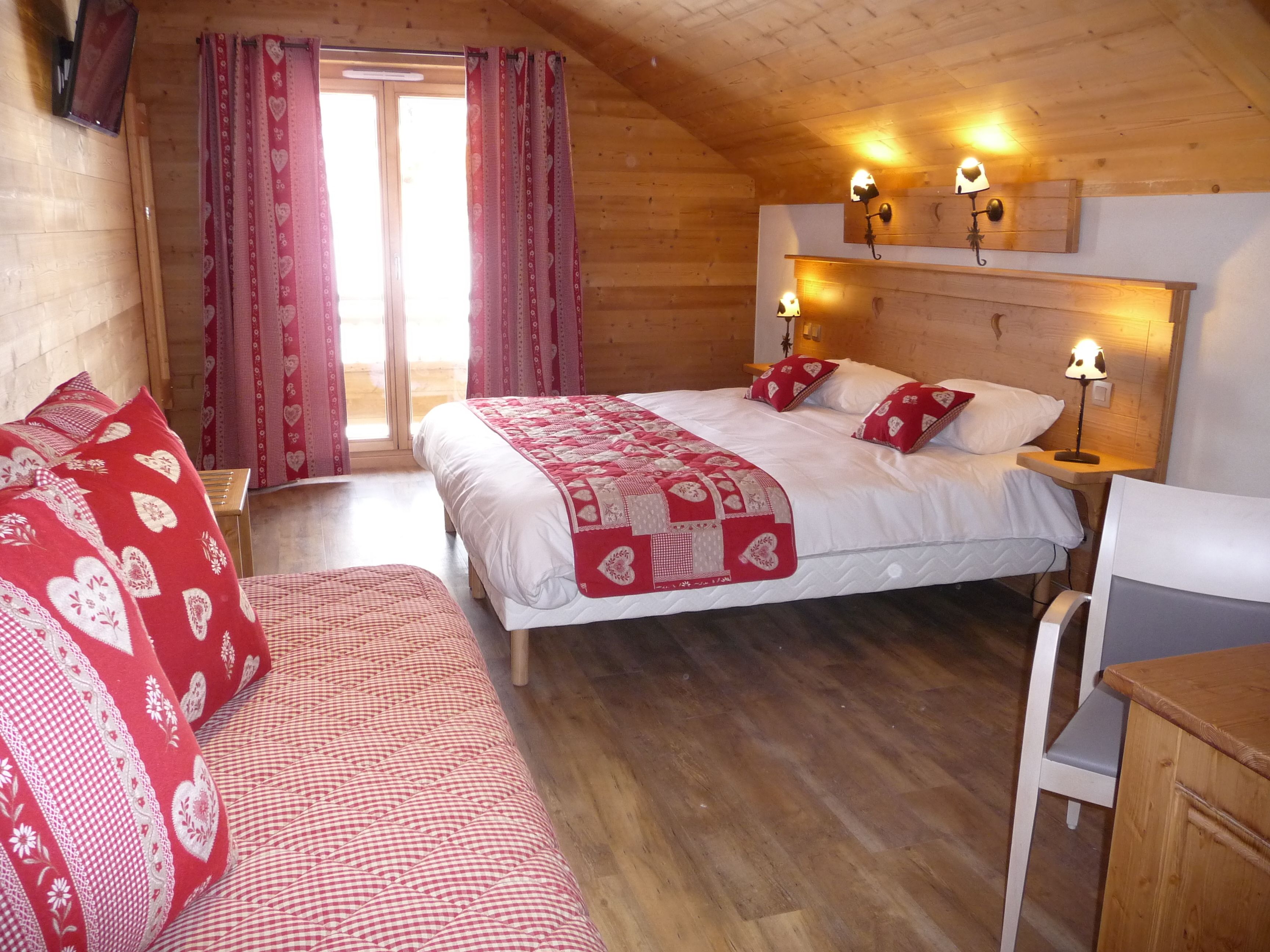Une chambre confortable avec un grand lit, deux tables de chevet avec des lampes, une tête de lit en bois et une fenêtre avec des rideaux.