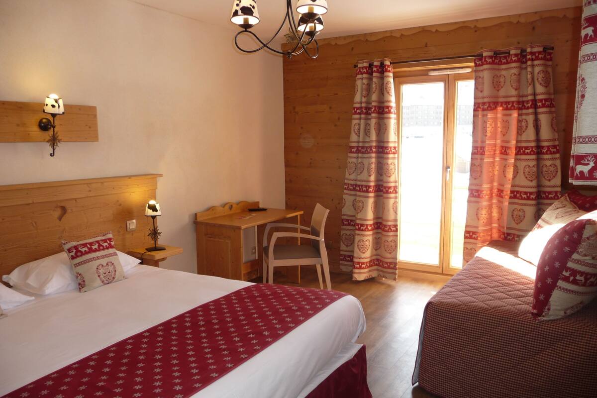 A cozy room with two beds, a desk, and a chair.