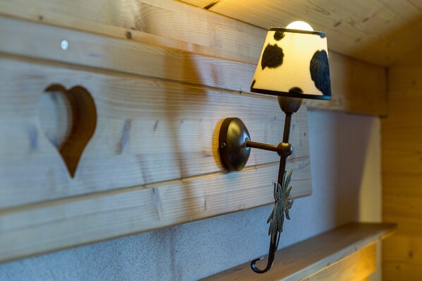 A wall-mounted lamp with a heart-shaped cutout and a decorative metal fixture.