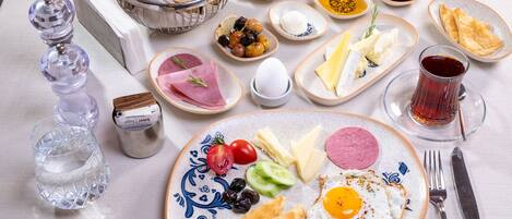 Una mesa de desayuno con diversos alimentos, como pan, huevos, queso y verduras.