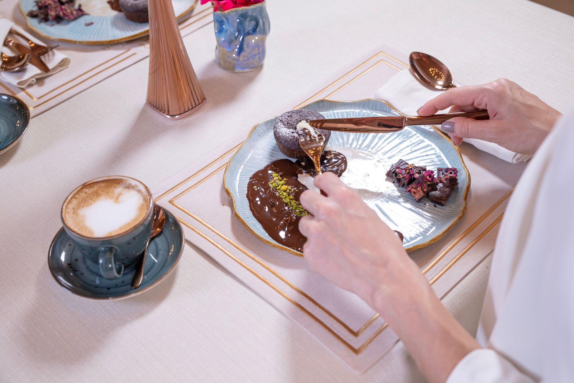 A person serving dessert on a plate with a spoon.
