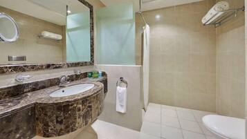 Un baño con lavamanos de mármol, espejo, toallero y zona de ducha.