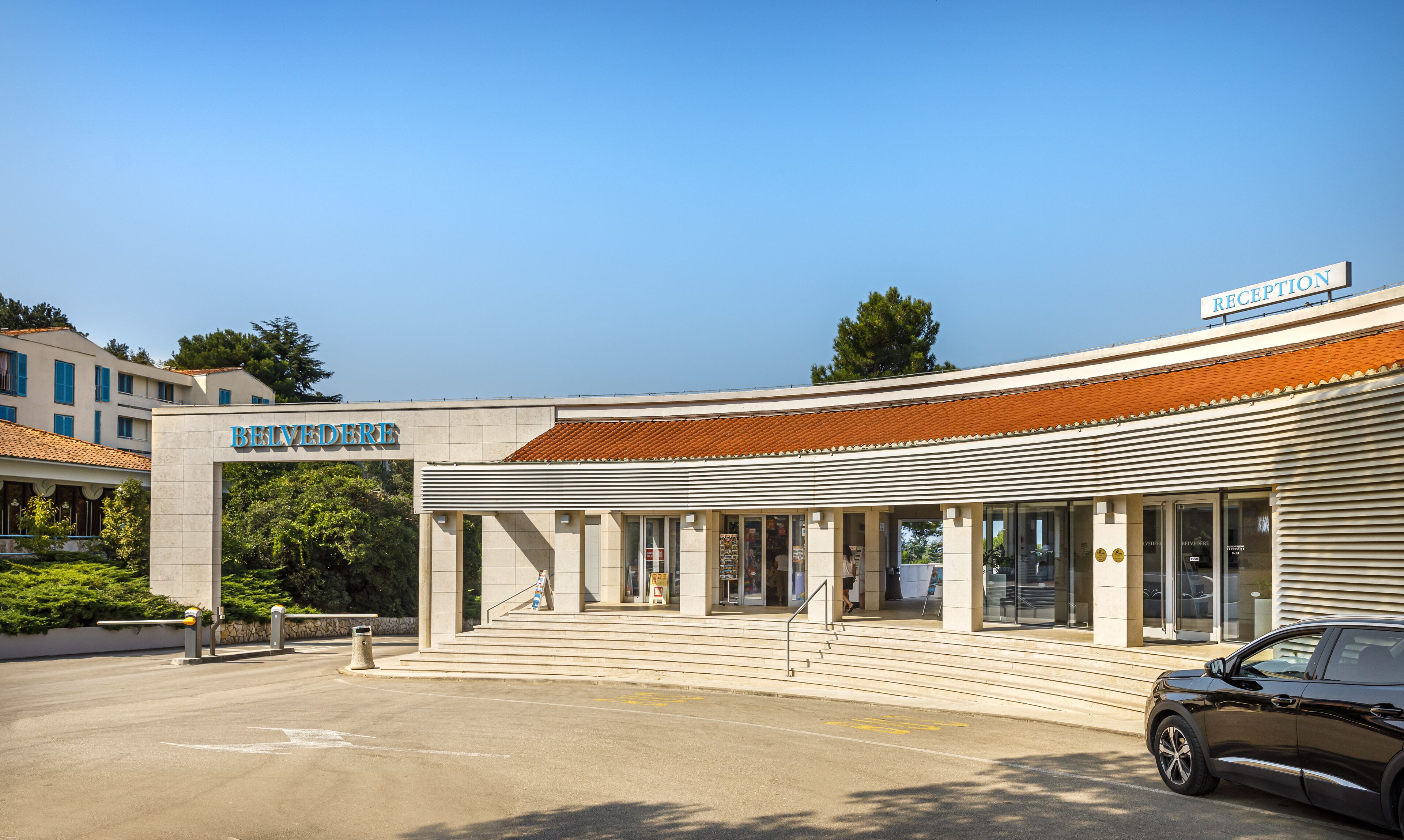 A hotel with a reception area, a tiled roof, and a sign that reads "BELVEDERE".