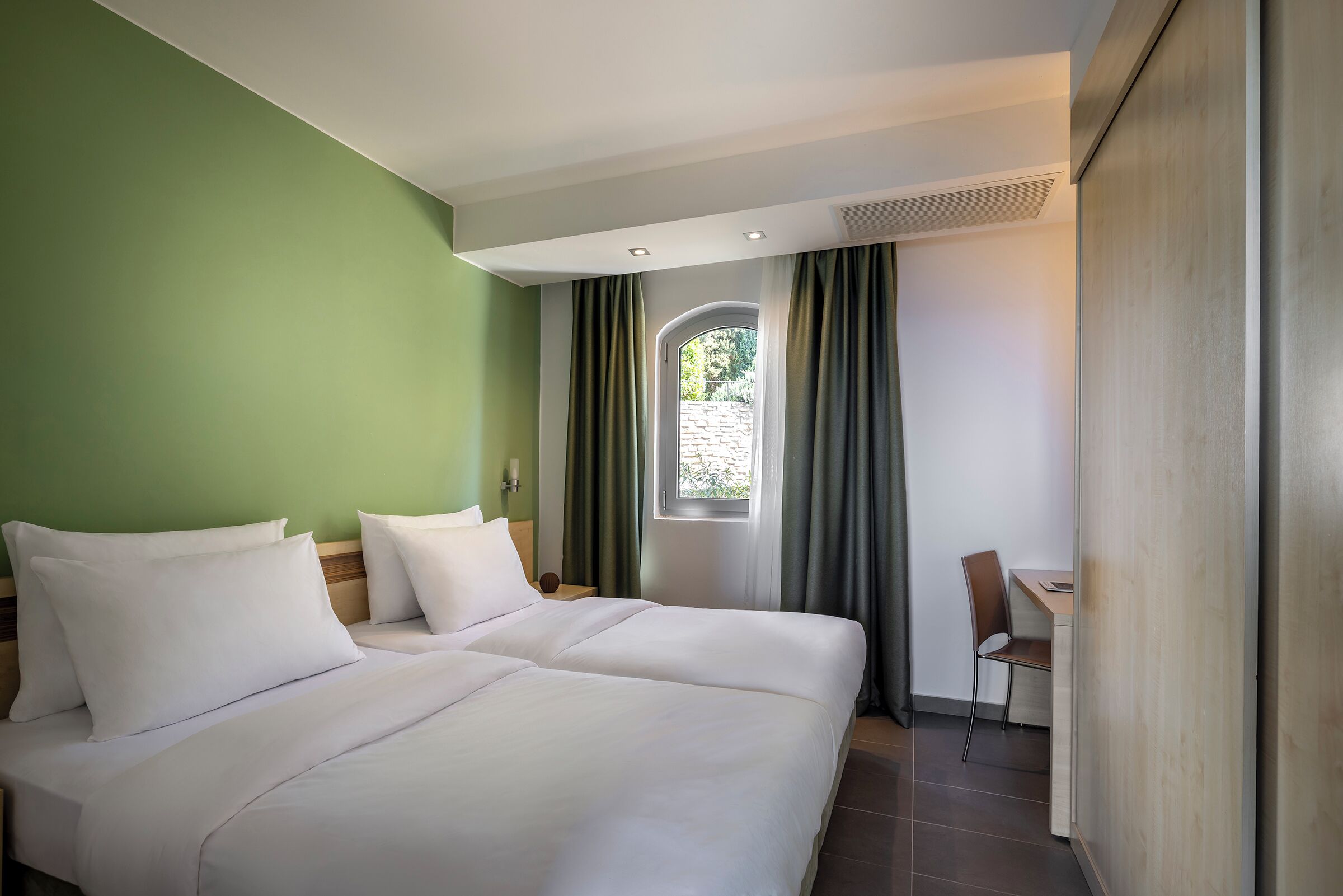 Ein Hotelzimmer mit Bett, Schreibtisch und Stuhl.