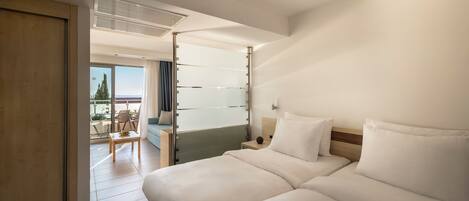 A hotel room with a large bed, a small table, and a view of the outdoors.