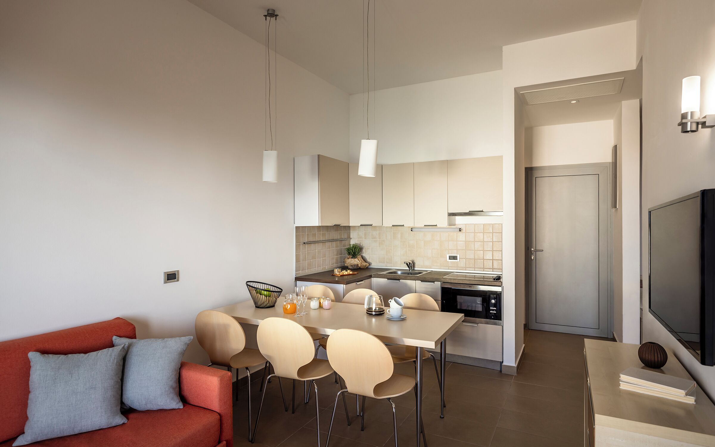 Een moderne keuken met een eethoek, een bank en een televisie.