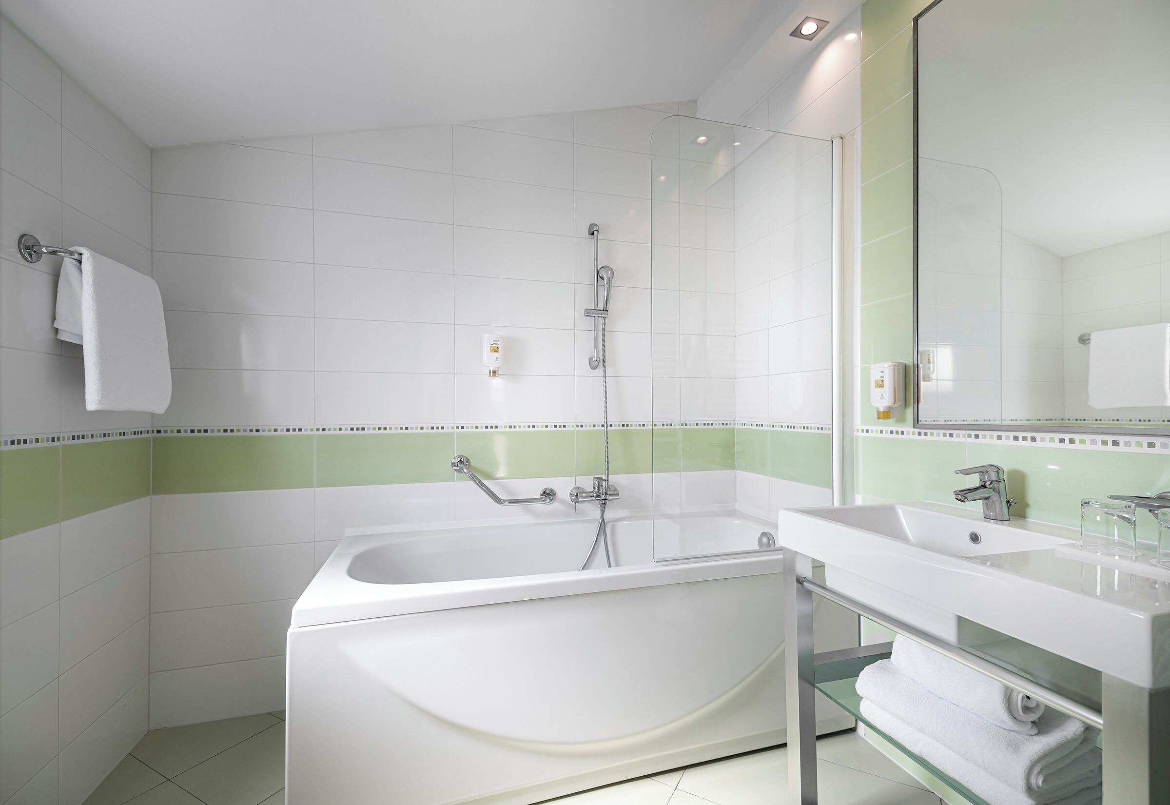 Un baño moderno con una bañera independiente, cabina de ducha de vidrio y tocador con espejo.