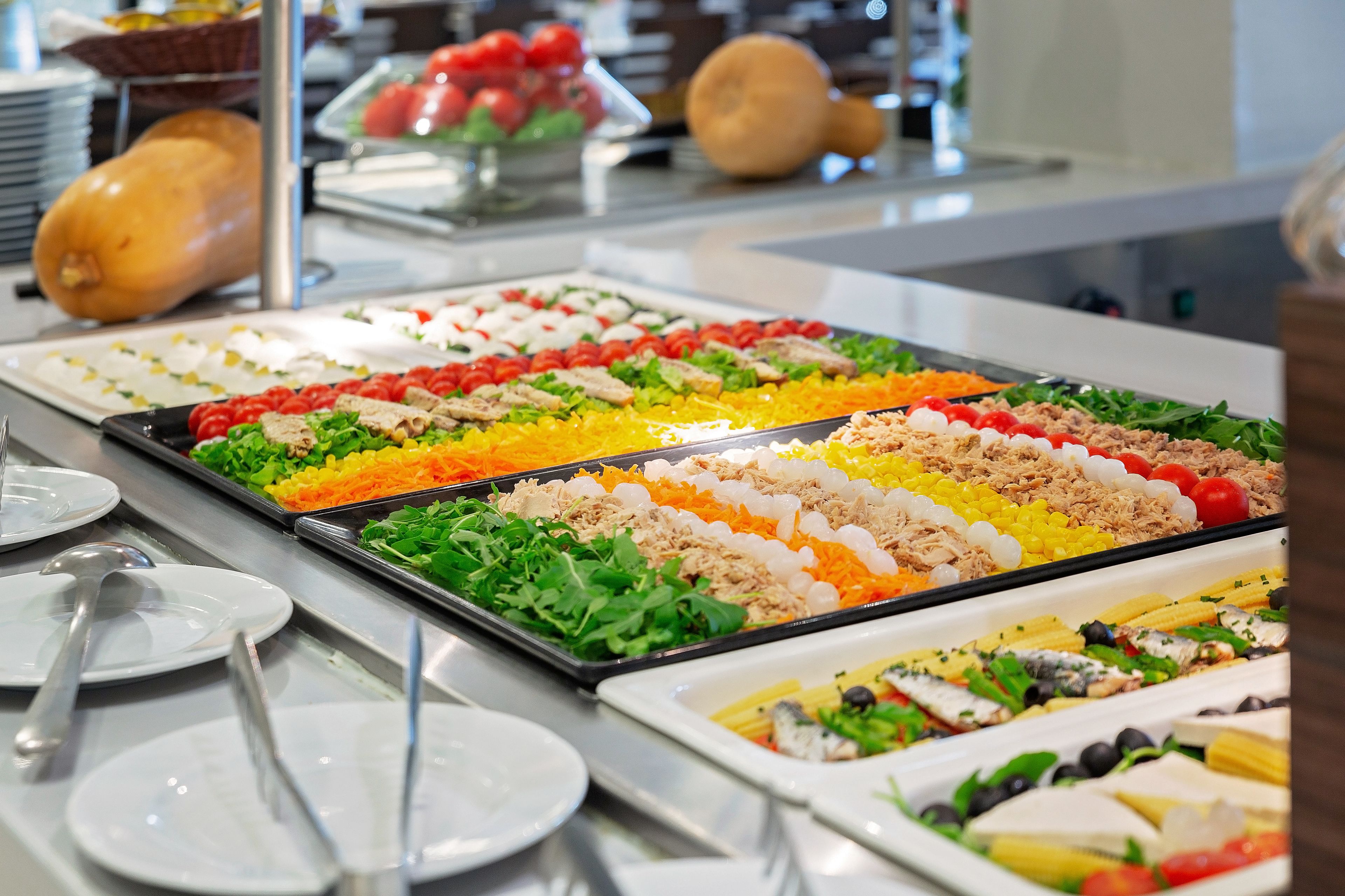 A buffet with various food options including salads, meats, and vegetables.