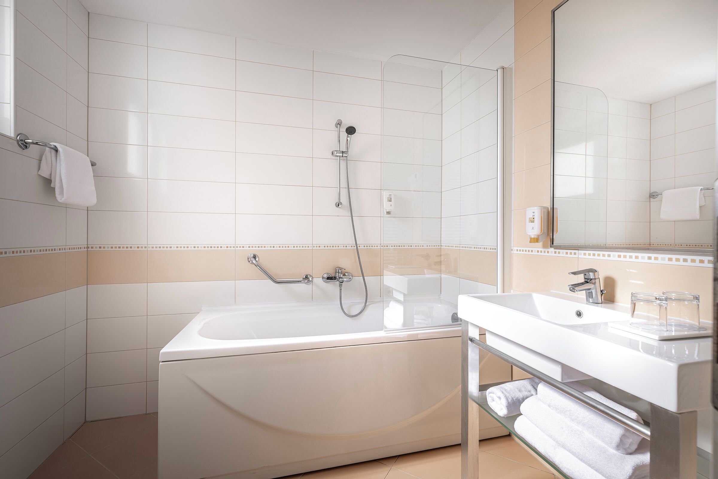 A modern bathroom with a freestanding bathtub, a glass-enclosed shower, and a vanity with a sink and mirror.