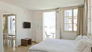Une chambre d’hôtel avec un lit, une télévision, une petite table et une chaise.