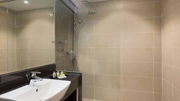 Un baño moderno con un espejo grande, un lavabo blanco y una zona de ducha.