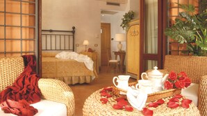 Ein gemütliches Zimmer mit einem Bett, einer Sitzecke mit Tisch und einem großen Fenster mit Blick.