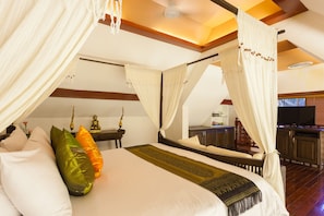 A bedroom with a large bed, white curtains, and a wooden ceiling. - Royal Phawadee Village (Patong)