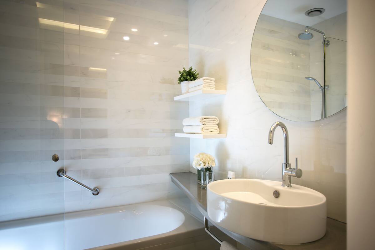deluxe room | bathroom | shower, rainfall showerhead, free toiletries, hair dryer