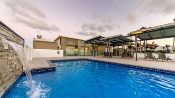 Alberca al aire libre y camastros