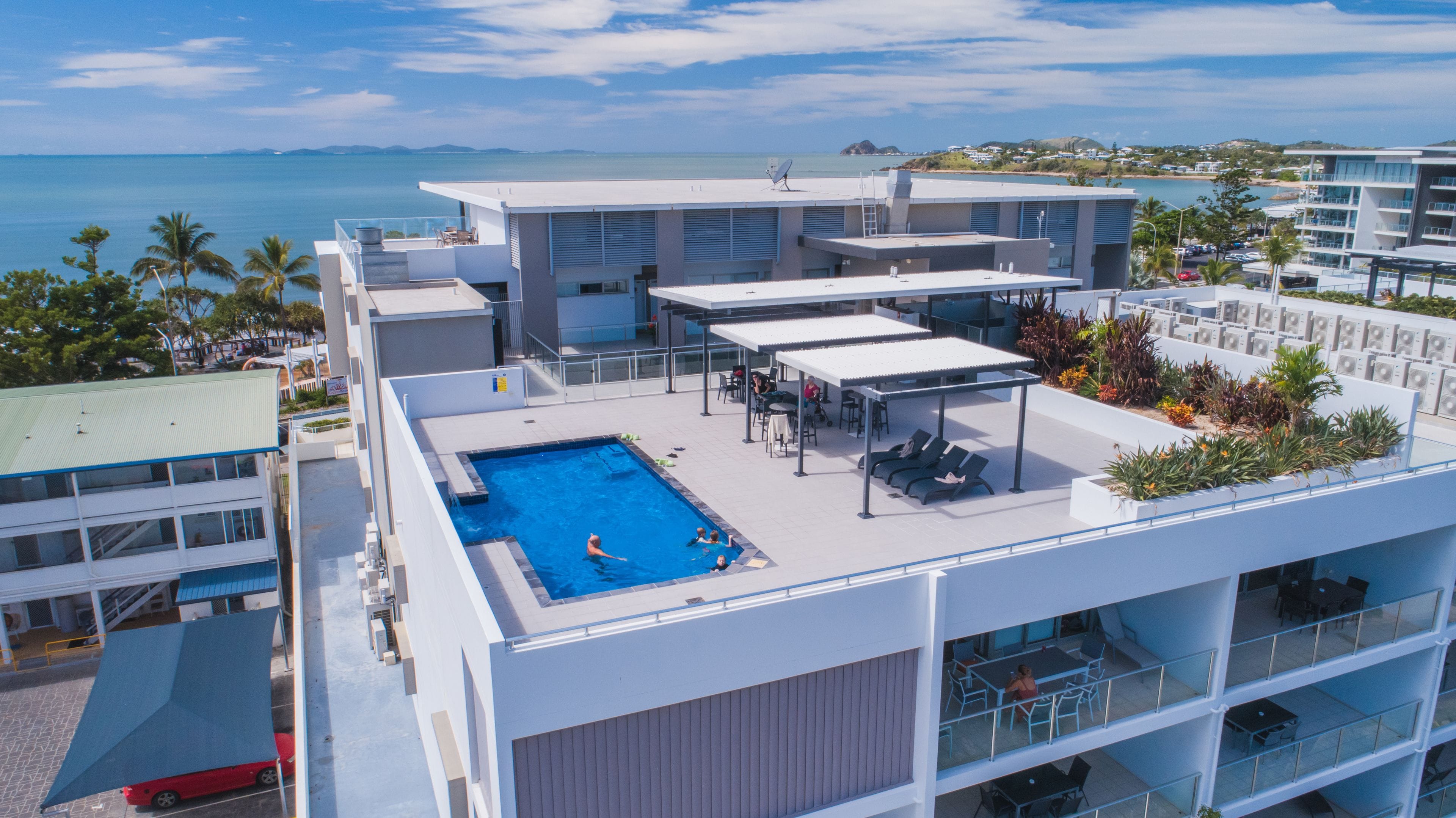 Una piscina al aire libre, sillones reclinables de piscina