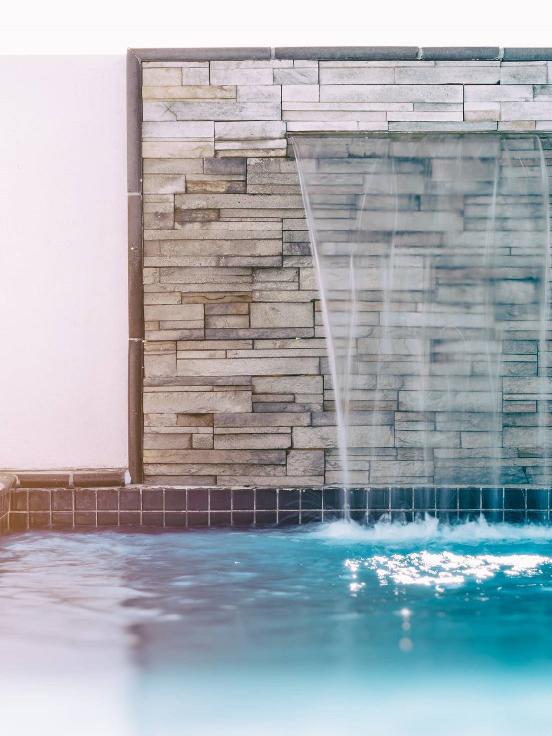 A stone wall with a water feature.