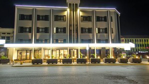 A multi-story hotel with a central atrium, large windows, and outdoor seating area. - Imperial Hotel Express (Kisumu)