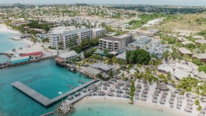 Une station balnéaire dotée d’un port de plaisance, d’une plage et de bungalows sur pilotis.