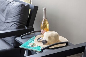 A magazine, a straw hat, and a bottle on a table. - The Beach House Curacao (Willemstad)