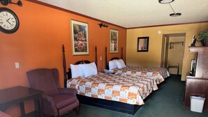 A hotel room with two beds, a chair, a desk, and a trash bin. - KC Motel (Show Low)