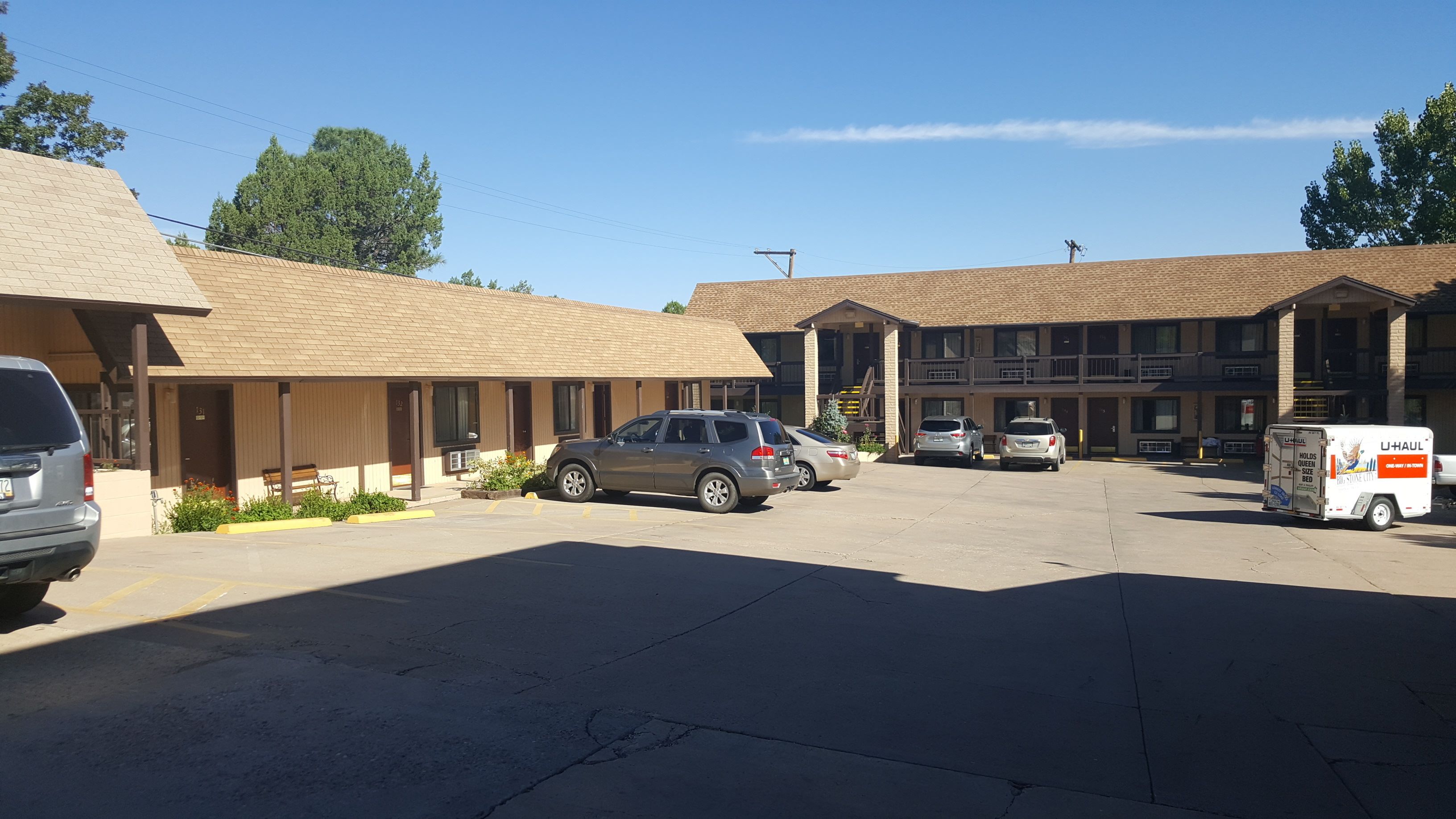 A motel with multiple rooms, a parking lot, and a U-Haul truck.