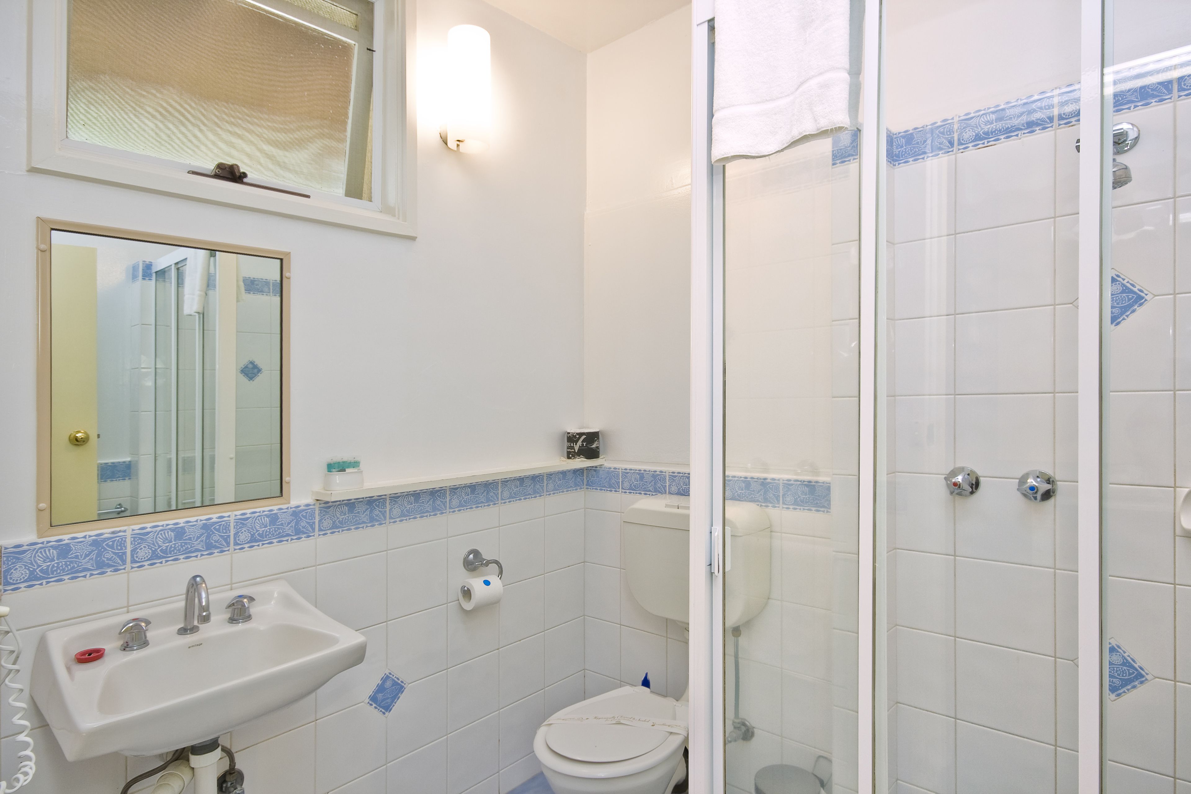 A bathroom with a sink, toilet, and shower.