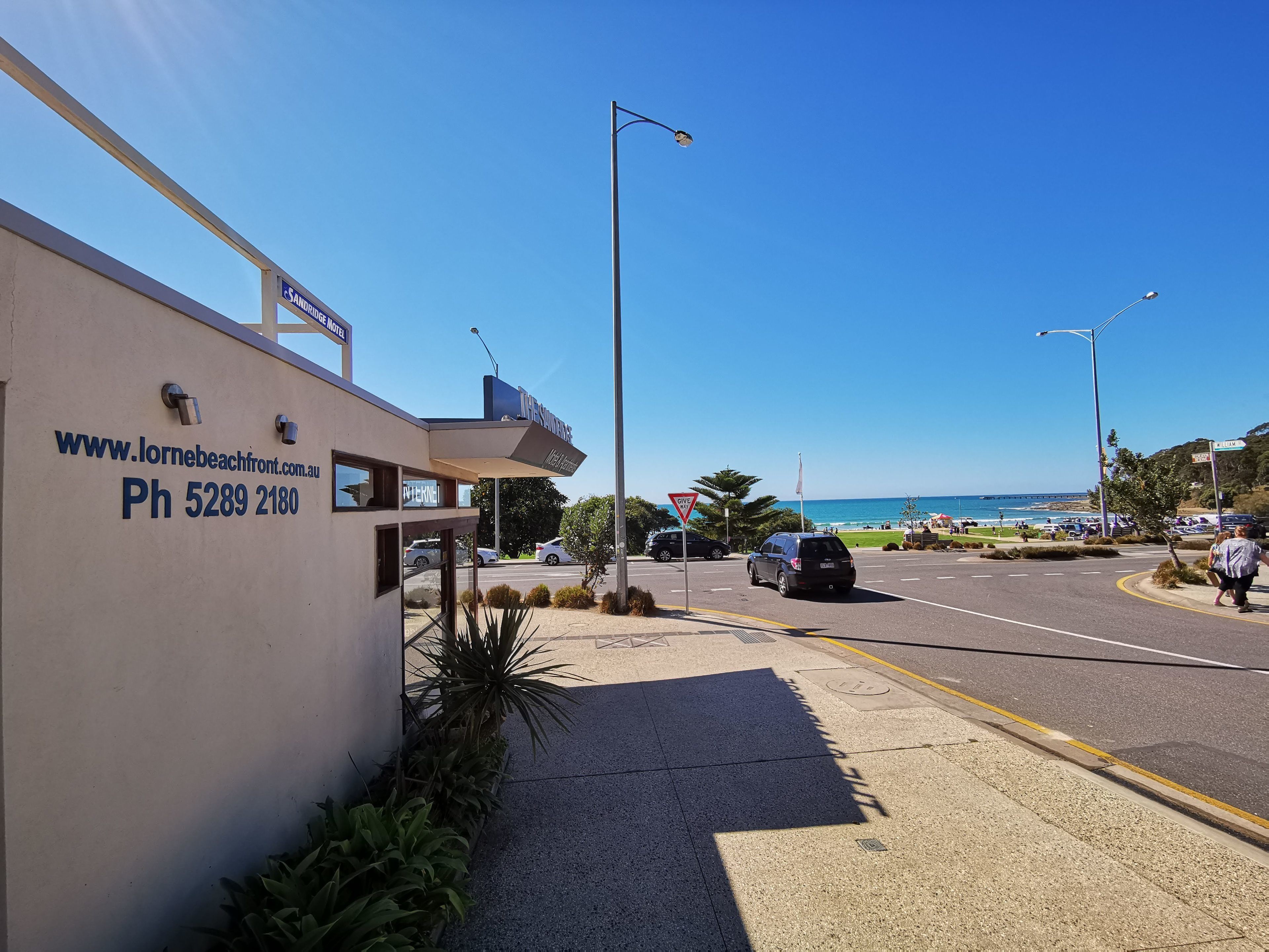 Ein Gebäude mit einem Schild für das Lorne Beachfront Hotel, inklusive Webseite und Telefonnummer.