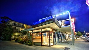 Un motel con un letrero llamativo, una entrada visible y un área de estacionamiento.