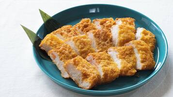 A bowl of breaded and fried food, possibly a type of Japanese dish, on a teal plate.