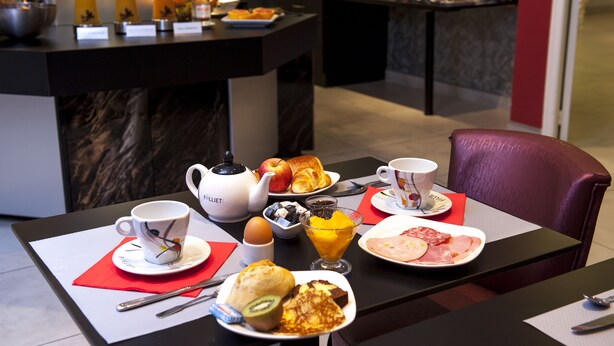 Una mesa con diversos alimentos, una tetera y una taza.