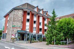 Et hotel med en stenfassade, mange vinduer og en glasindgang.