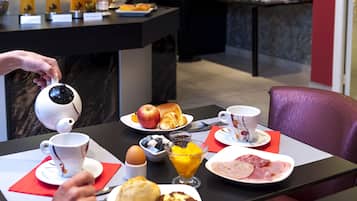 A breakfast buffet with various food items and a coffee machine.