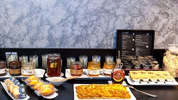 A buffet table with various food items and condiments.