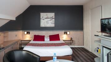 A hotel room with a bed, a desk, a chair, a television, and a painting on the wall.