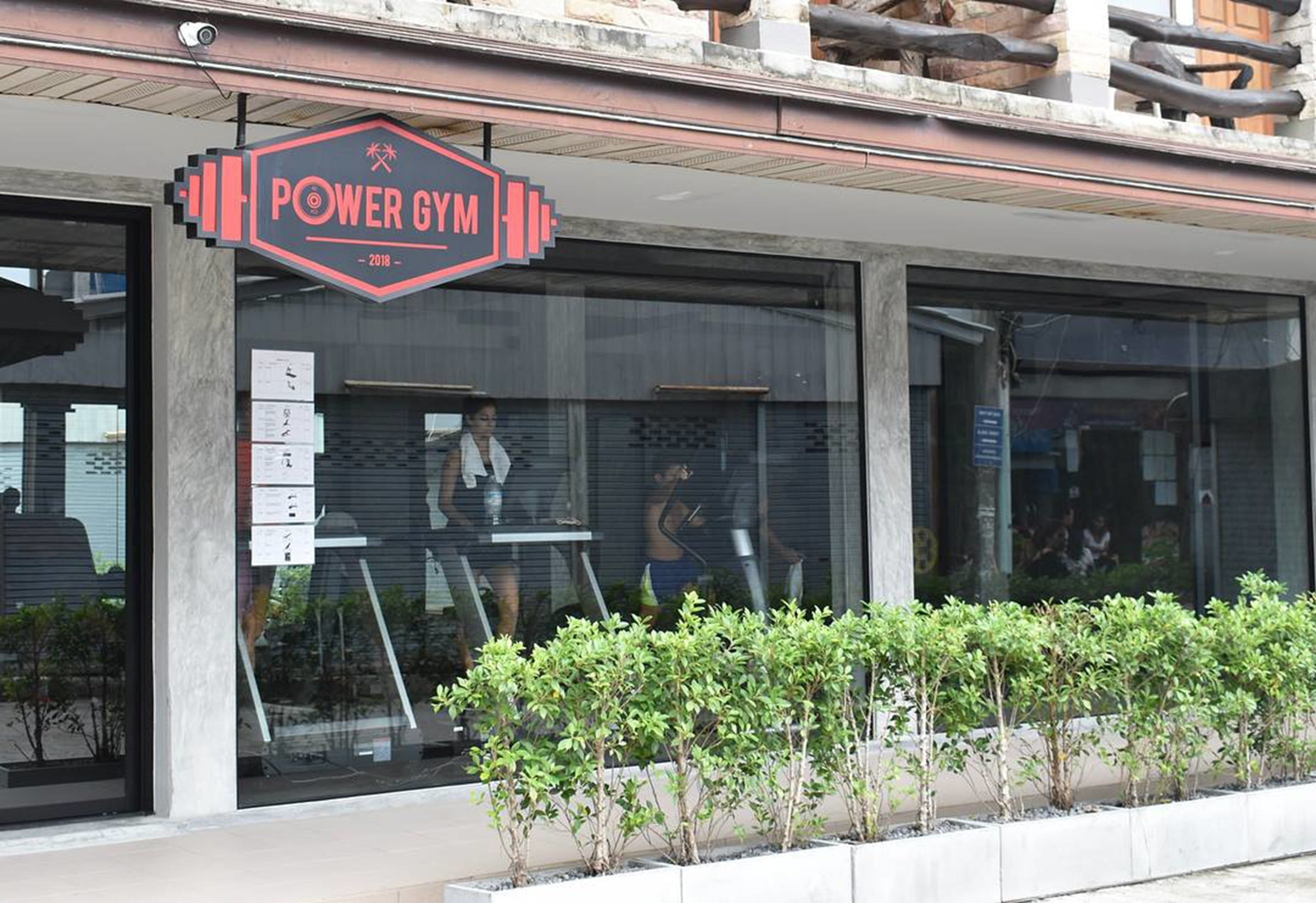 A gym with a sign reading "POWER GYM" and a modern building facade.