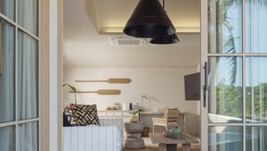 Un baño moderno con una bañera blanca grande, una mesita de centro de madera y una zona de estar con sofá y sillones.