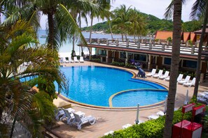 Una piscina al aire libre, sombrillas, sillones reclinables de piscina